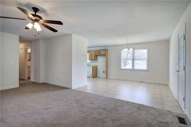 an empty room with windows and ceiling fan
