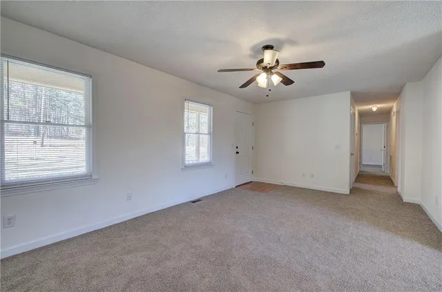 a view of a room with chandelier fan and windows