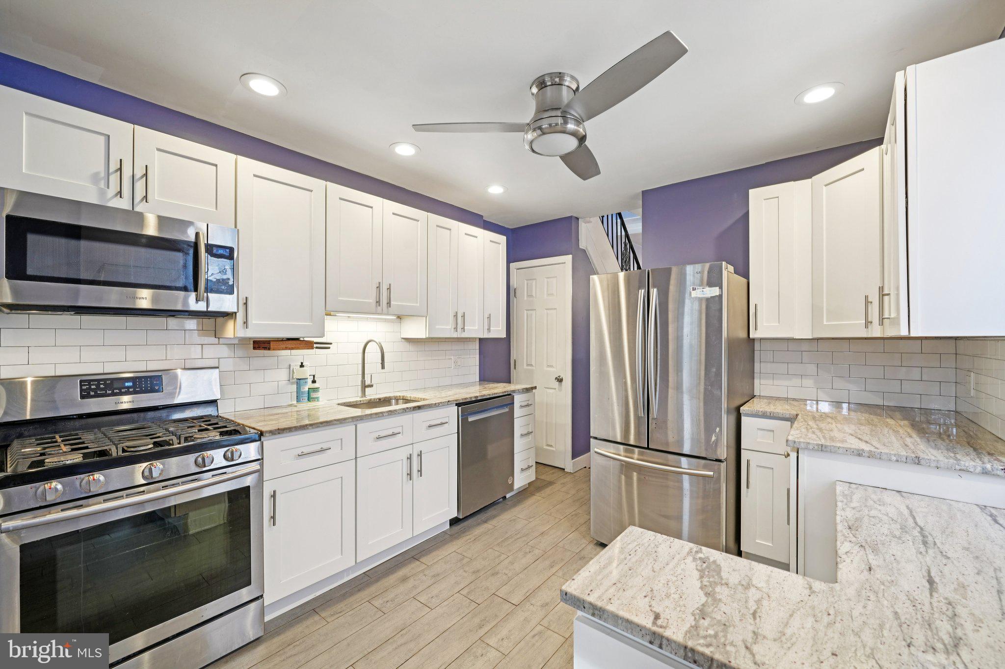 3008 Poplar Street Philadelphia, PA 19130 - Photo 13 of 50 a kitchen with granite countertop a sink stainless steel appliances and cabinets