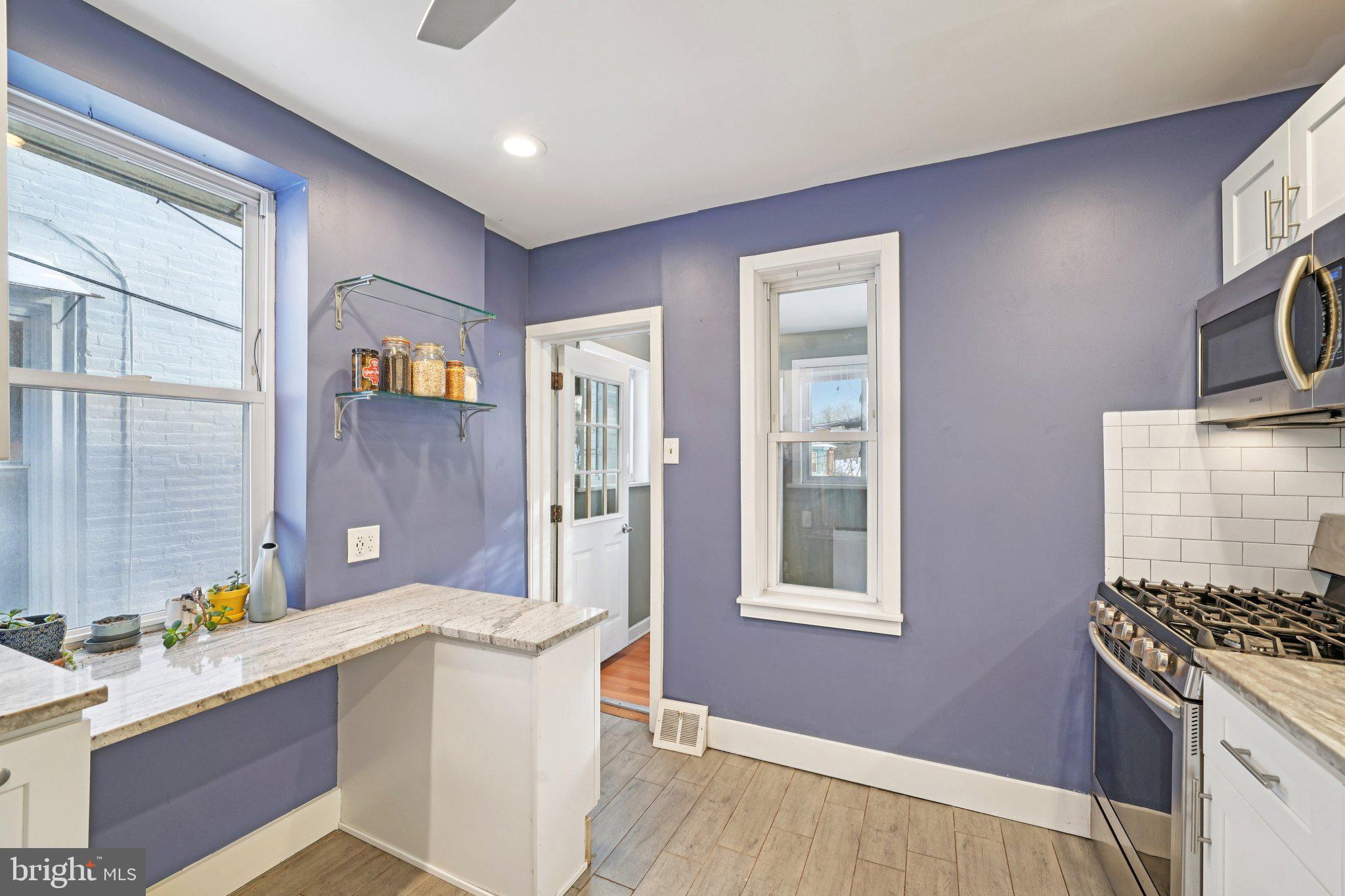 3008 Poplar Street Philadelphia, PA 19130 - Photo 14 of 50 a kitchen with stainless steel appliances granite countertop a stove a sink and a refrigerator