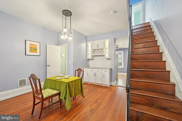 a view of a hallway with wooden floor and staircase