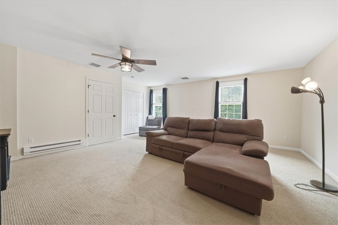 26 Davis Circle Warwick, RI 02886 - Photo 24 of 50 Currently used as a spacious 4th bedroom, this oversized retreat features plush carpeting, abundant natural light, ceiling fan, generous proportions, a large walk-in closet, and plenty of room for both sleeping and lounging. Whether you envision a luxurious primary-style suite, media room, game room, teen hangout, home office, or second family room, this versatile space easily adapts to your needs.
