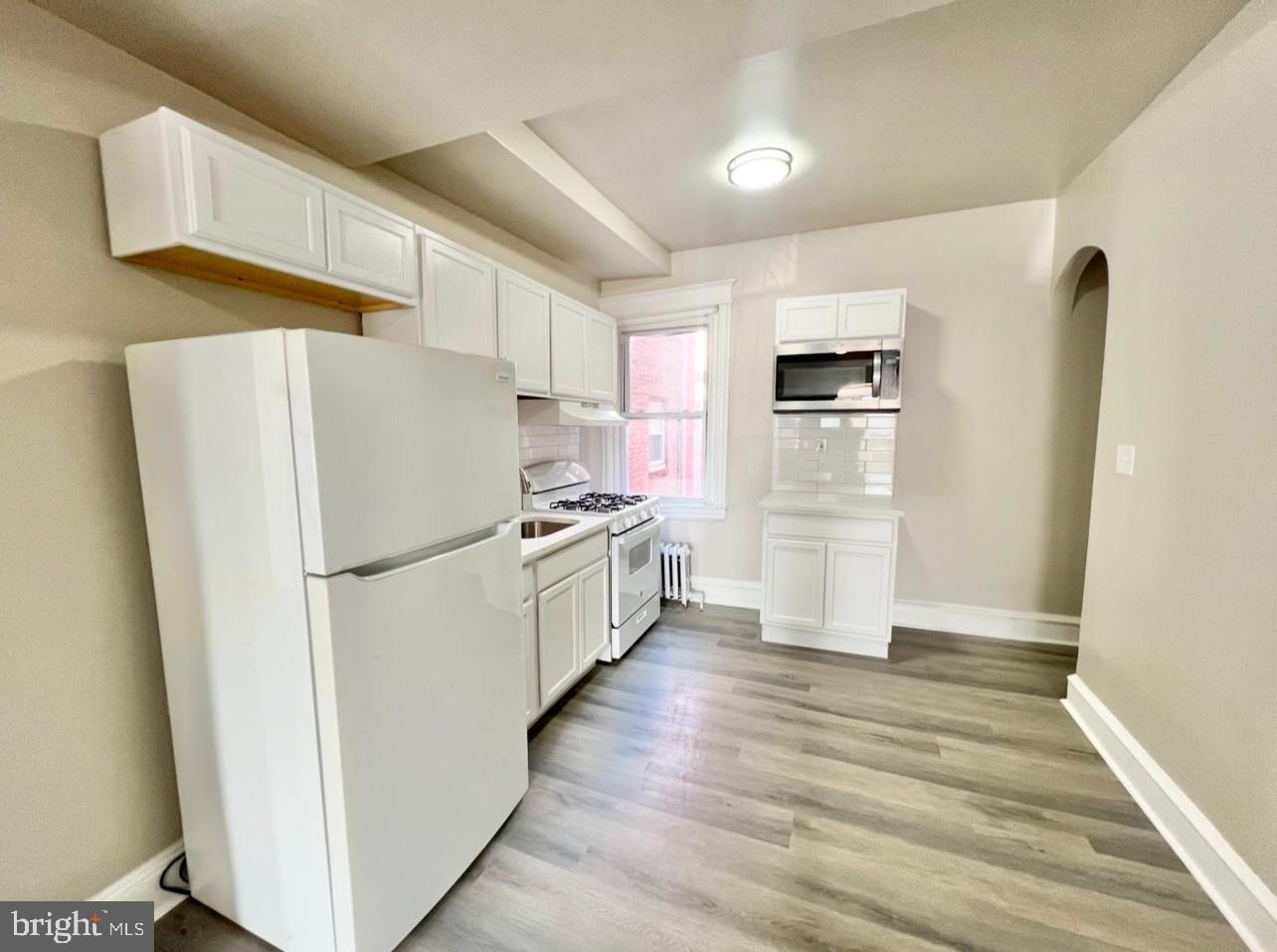 1607 South 60th Street, Unit 1 Philadelphia, PA 19142 - Photo 9 of 16 a kitchen with stainless steel appliances a refrigerator a sink and white cabinets