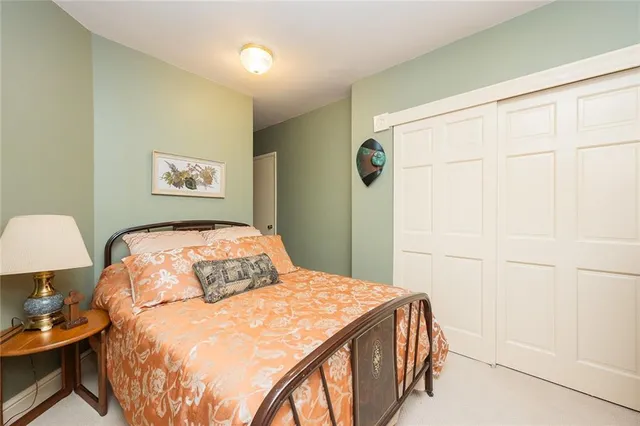 a bedroom with a bed and a lamp on dresser