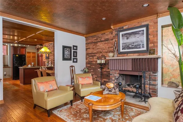 a living room with furniture a fireplace and a large window