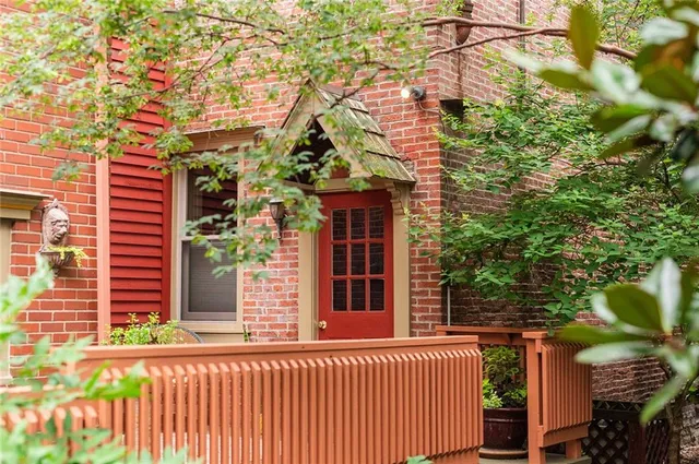 a view of a house with a tree and wooden fence