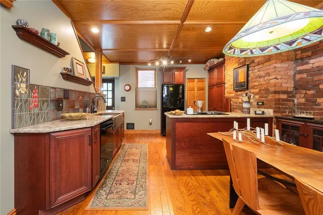 a dining room with stainless steel appliances granite countertop a sink and cabinets