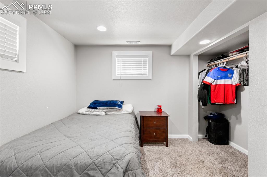 125 Chelton Road Colorado Springs, CO 80909 - Photo 17 of 26 a bedroom with furniture and a bed