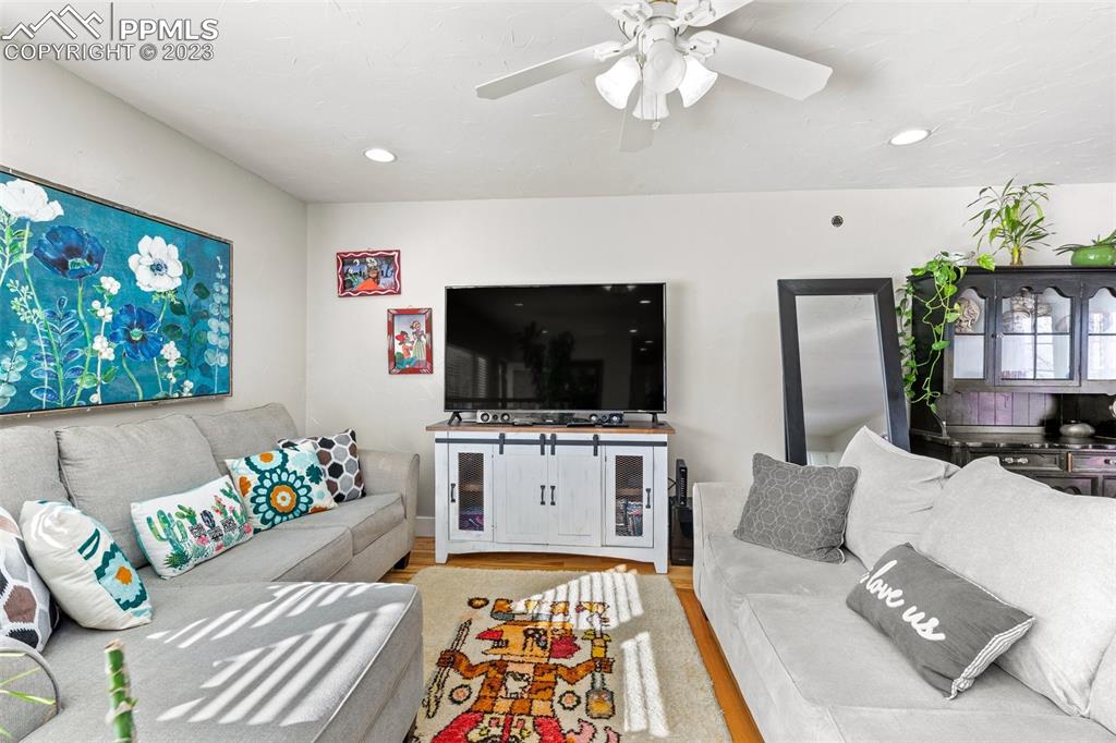 125 Chelton Road Colorado Springs, CO 80909 - Photo 2 of 26 a living room with furniture and a flat screen tv