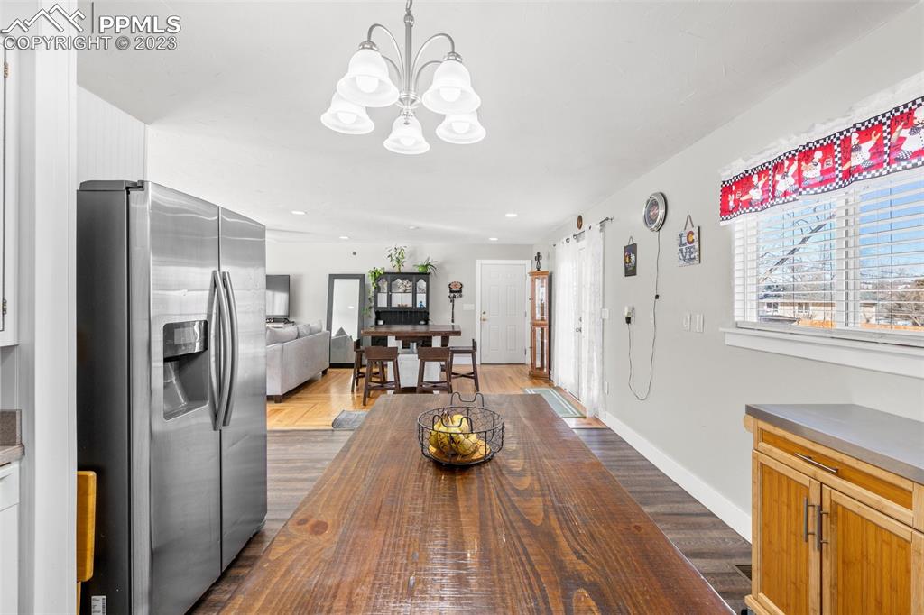 125 Chelton Road Colorado Springs, CO 80909 - Photo 10 of 26 a view of a dining room with furniture a chandelier and wooden floor