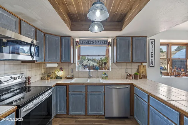 a kitchen with stainless steel appliances granite countertop a sink a stove and cabinets