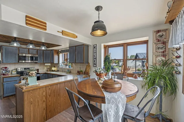 a view of a dining room and livingroom with furniture wooden floor a rug a painting and a chandelier