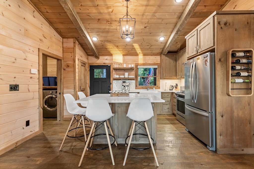 361 June Bug Lane Blue Ridge, GA 30513 - Photo 15 of 65 a kitchen with stainless steel appliances granite countertop a refrigerator a sink dishwasher a dining table and chairs with wooden floor