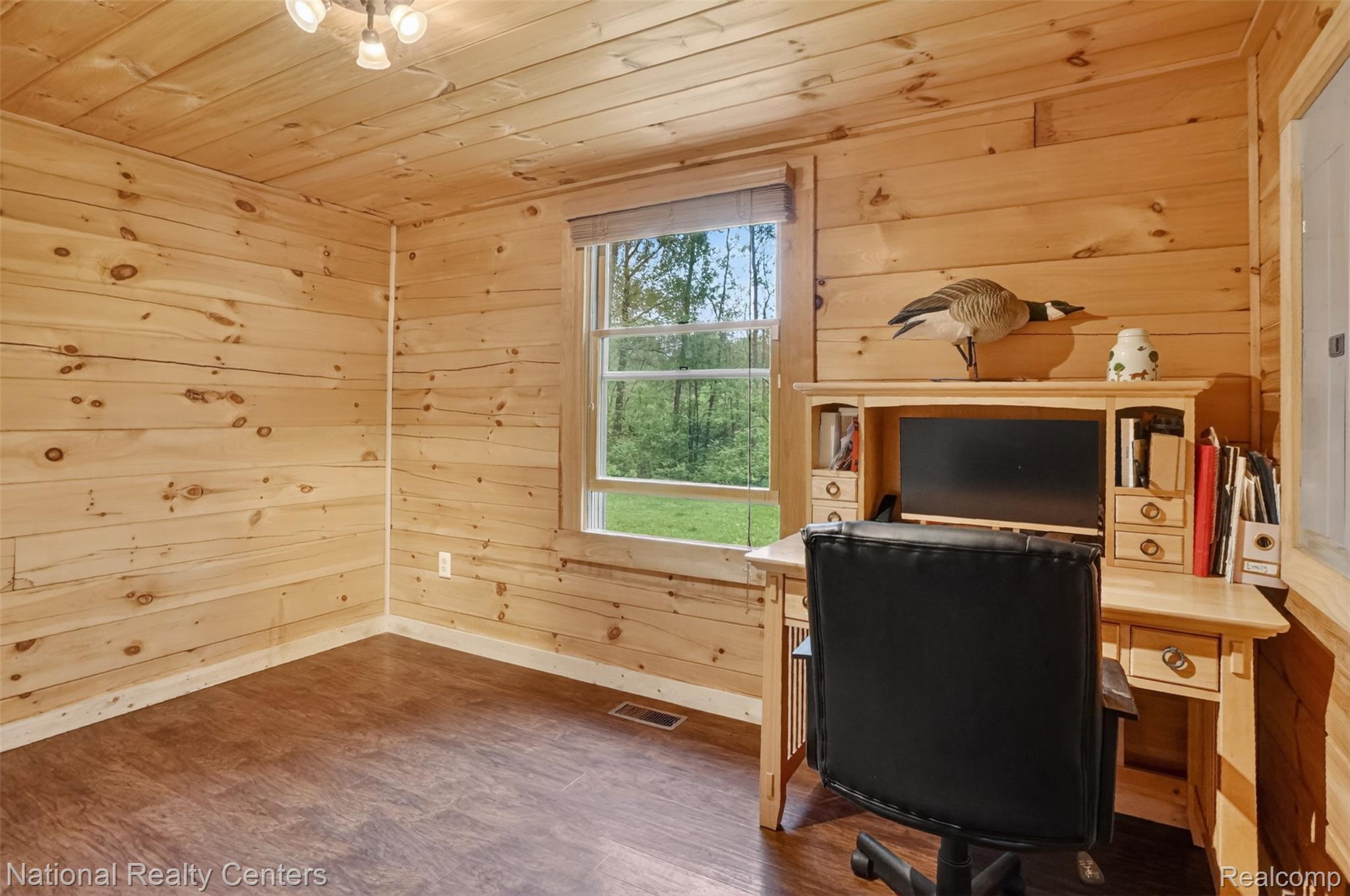 7782 Golf Club Road Howell, MI 48843 - Photo 11 of 27 Pine paneling throughout, wood-finish flooring, and a window with natural light