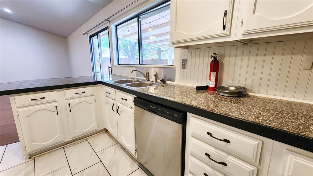 3905 Windflower Lane Fort Worth, TX 76137 - Photo 11 of 32 a kitchen with granite countertop white cabinets and white appliances