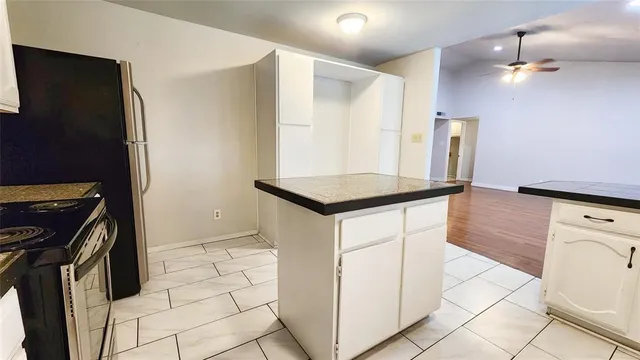 a kitchen with stainless steel appliances granite countertop a stove a refrigerator and a cabinets