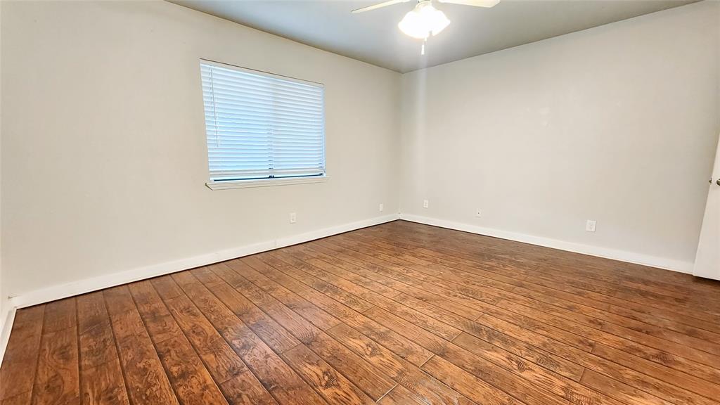 3905 Windflower Lane Fort Worth, TX 76137 - Photo 22 of 32 an empty room with wooden floor and windows