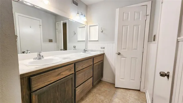 a bathroom with a double vanity sink and a mirror