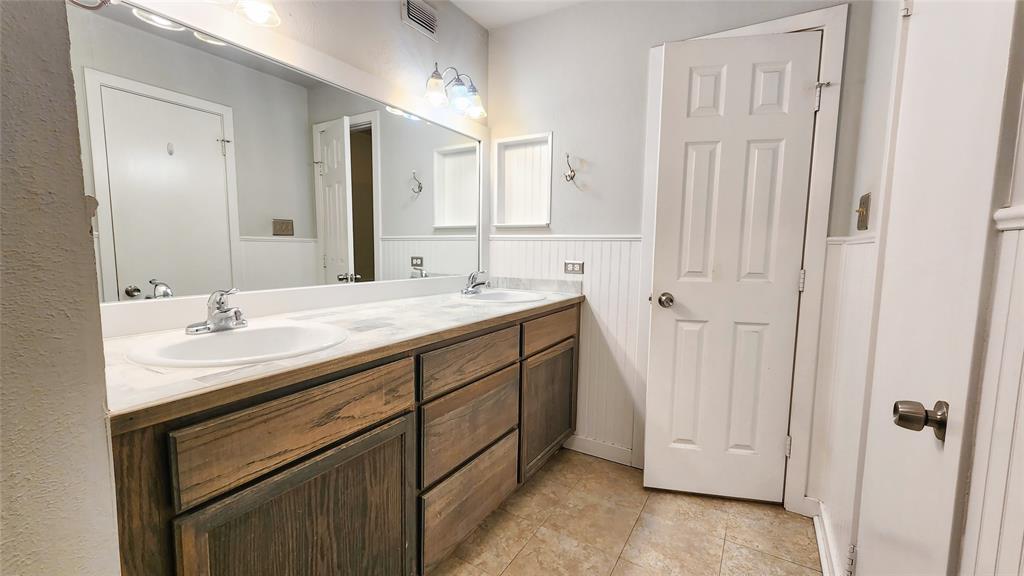 3905 Windflower Lane Fort Worth, TX 76137 - Photo 23 of 32 a bathroom with a double vanity sink and a mirror