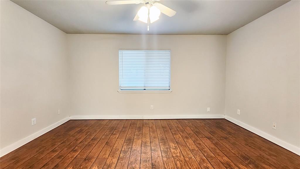 3905 Windflower Lane Fort Worth, TX 76137 - Photo 28 of 32 an empty room with wooden floor and windows