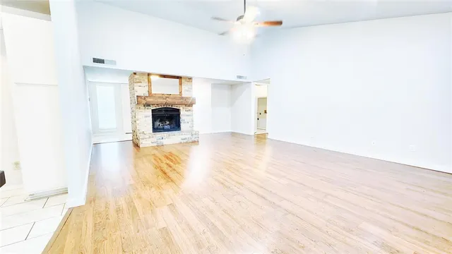 a view of a livingroom with wooden floor a fireplace and windows