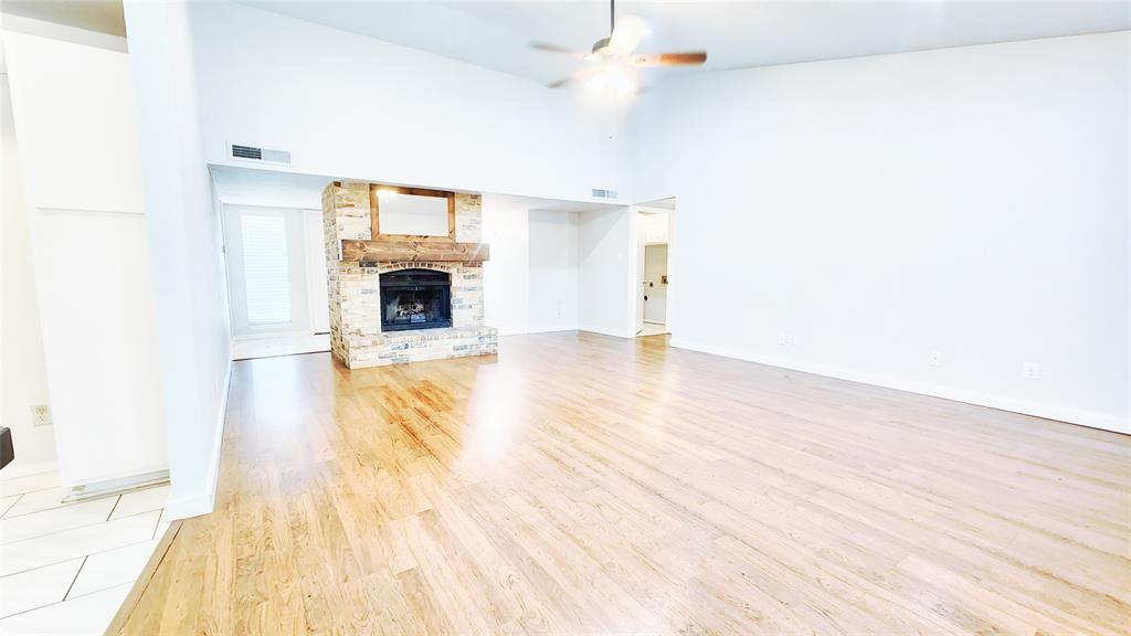 3905 Windflower Lane Fort Worth, TX 76137 - Photo 4 of 32 a view of a livingroom with wooden floor a fireplace and windows
