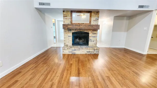 a view of a livingroom with wooden floor and a fireplace
