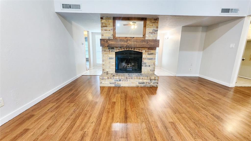 3905 Windflower Lane Fort Worth, TX 76137 - Photo 5 of 32 a view of a livingroom with wooden floor and a fireplace