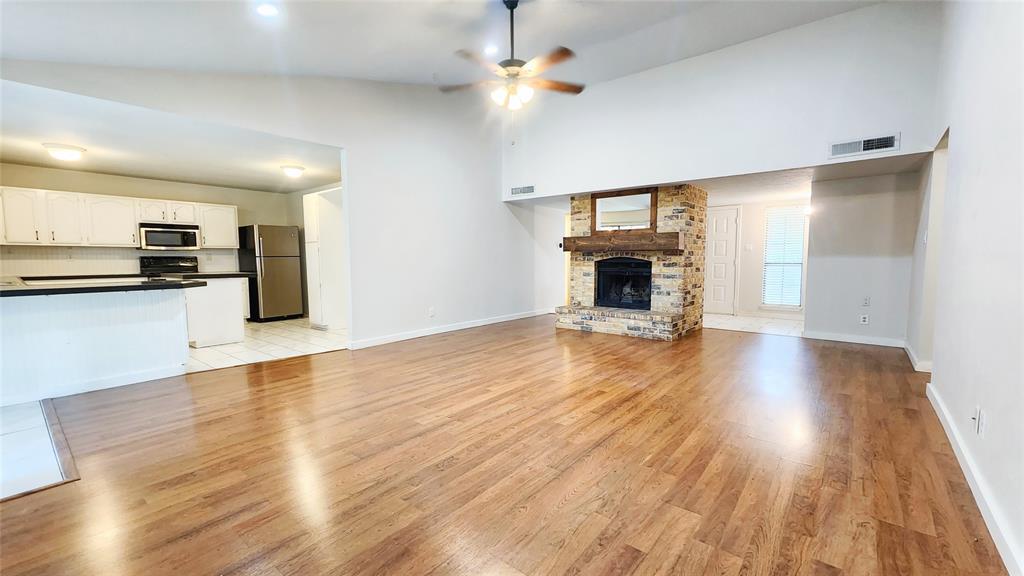 3905 Windflower Lane Fort Worth, TX 76137 - Photo 7 of 32 a view of a kitchen with wooden floor and a fireplace