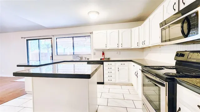 a kitchen with stainless steel appliances granite countertop a sink stove and cabinets
