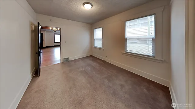 an empty room with windows and closet