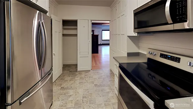 a kitchen with stainless steel appliances a refrigerator and a stove top oven