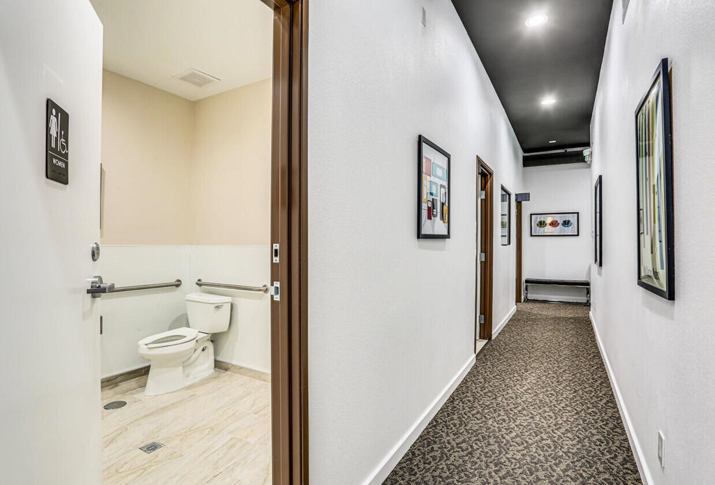 750 East Tahquitz Canyon Way, Unit 5 Palm Springs, CA 92262 - Photo 11 of 19 a view of a hallway with toilet and tub