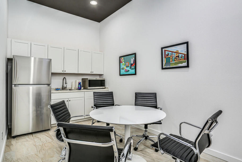750 East Tahquitz Canyon Way, Unit 5 Palm Springs, CA 92262 - Photo 9 of 19 a kitchen with stainless steel appliances a refrigerator and a table