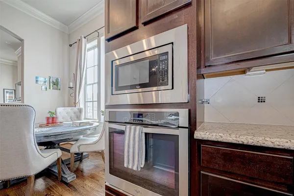 a kitchen with stainless steel appliances granite countertop a stove top oven a sink dishwasher a refrigerator and cabinets with wooden floor