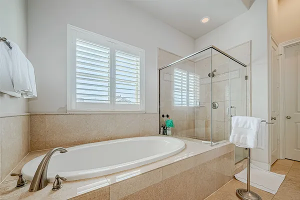 a white bath tub sitting in a bathroom next to a window