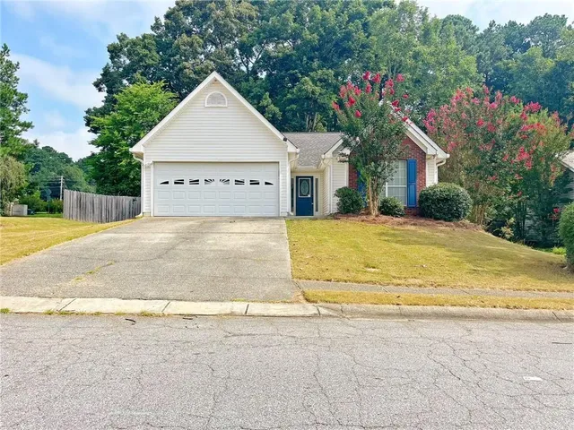 a view of a house with a yard and potted plants
