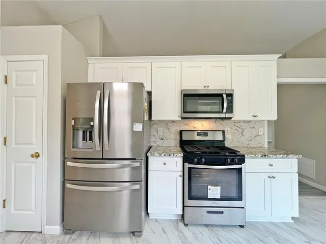 a kitchen with stainless steel appliances a refrigerator stove and microwave