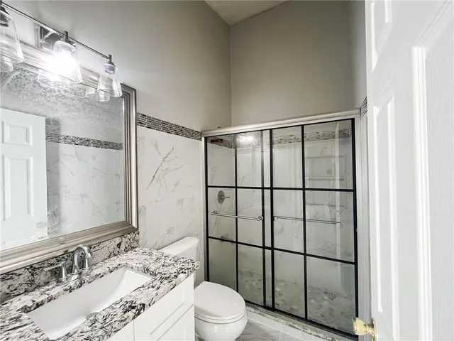 a bathroom with a sink a toilet and shower