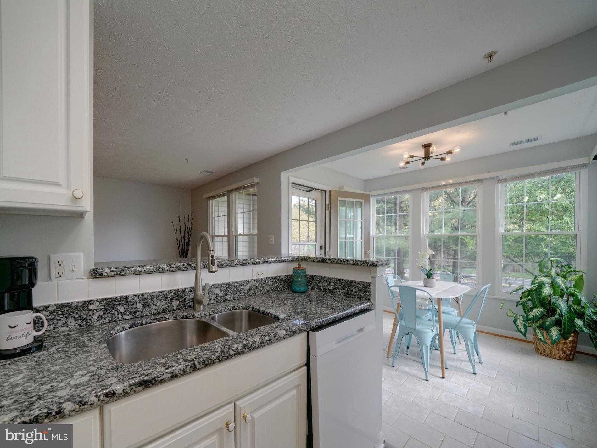 a kitchen with granite countertop a sink and a large window