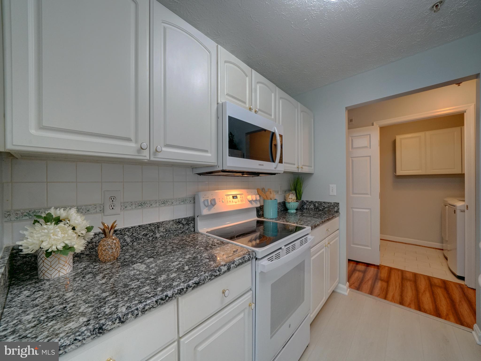693 Winding Stream Way, Unit 103 Odenton, MD 21113 - Photo 3 of 26 a kitchen with granite countertop a sink stainless steel appliances and cabinets