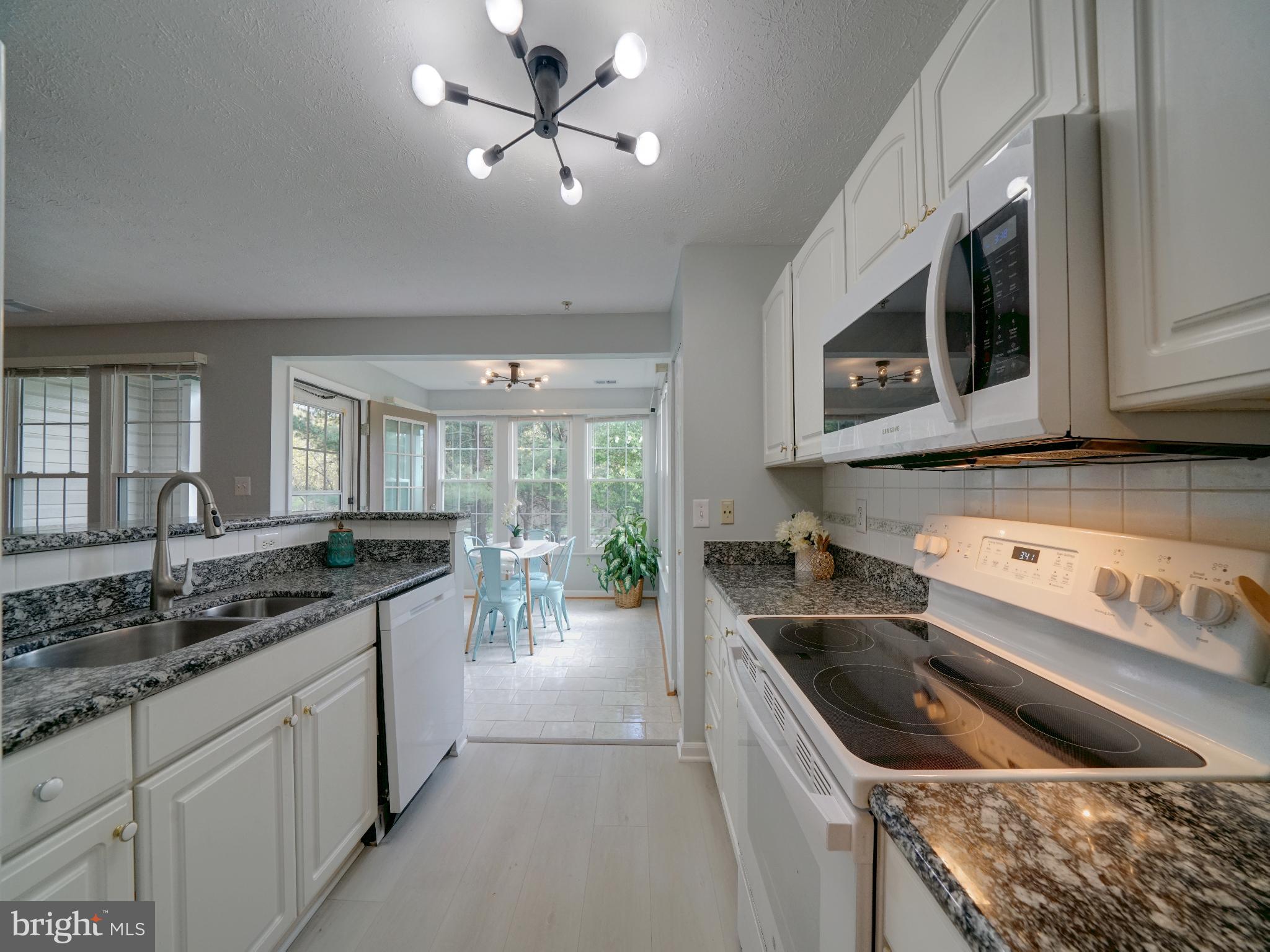 693 Winding Stream Way, Unit 103 Odenton, MD 21113 - Photo 4 of 26 a kitchen with stainless steel appliances granite countertop a sink and stove