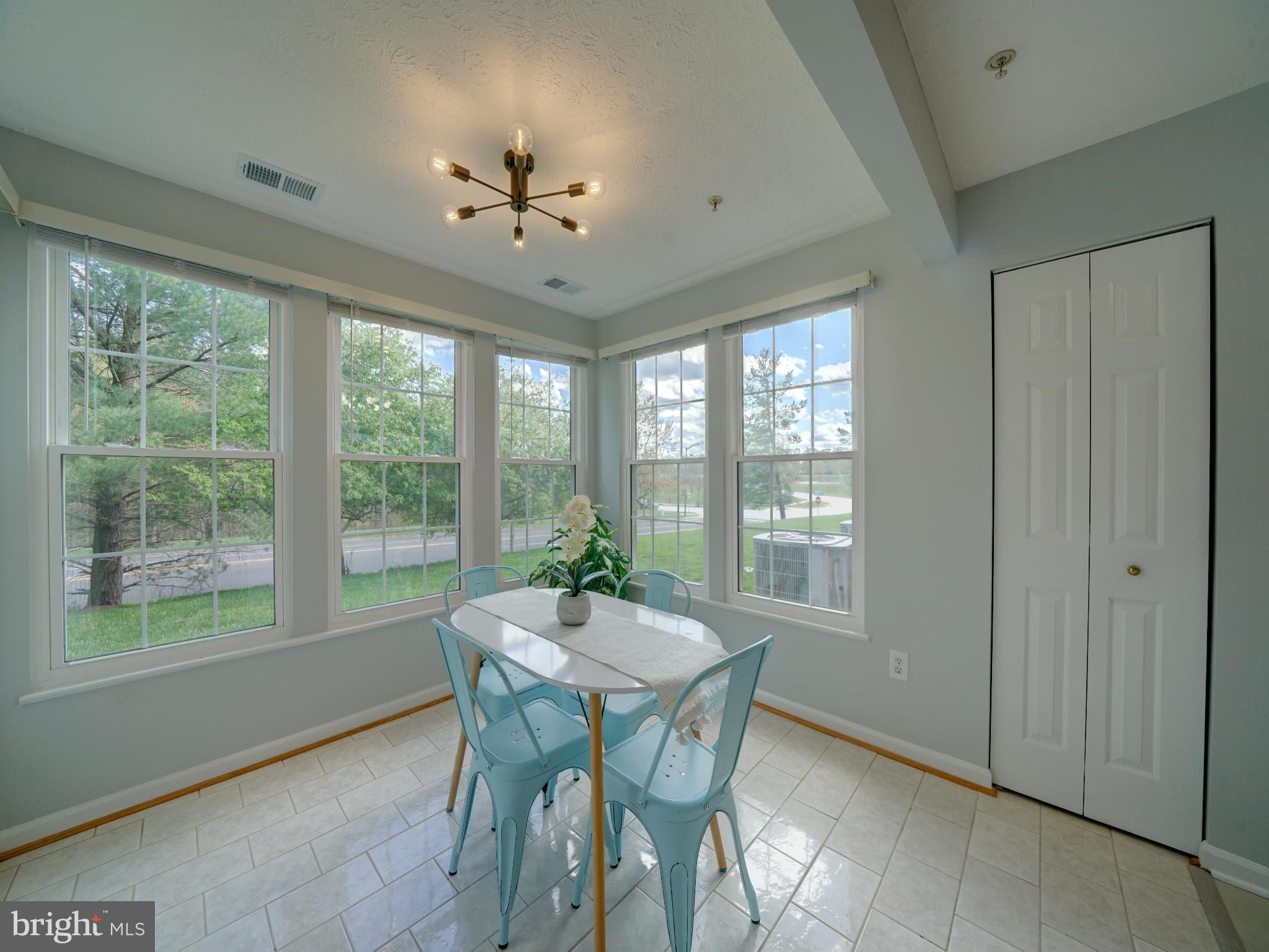 693 Winding Stream Way, Unit 103 Odenton, MD 21113 - Photo 5 of 26 a dining room with furniture a chandelier and wooden floor