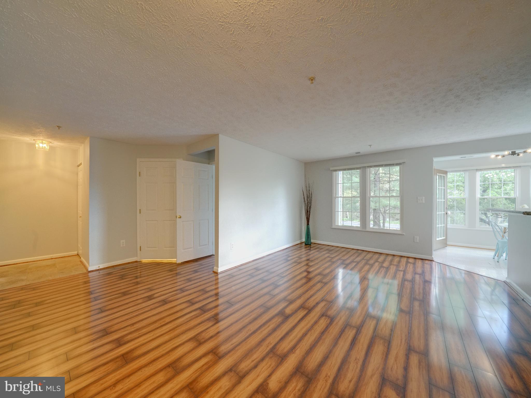 693 Winding Stream Way, Unit 103 Odenton, MD 21113 - Photo 10 of 26 a view of an empty room with wooden floor and a window