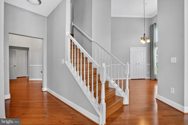 a view of staircase with lots of frames on wall and wooden floor
