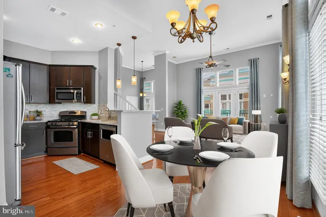 a kitchen with a dining table chairs stainless steel appliances and cabinets