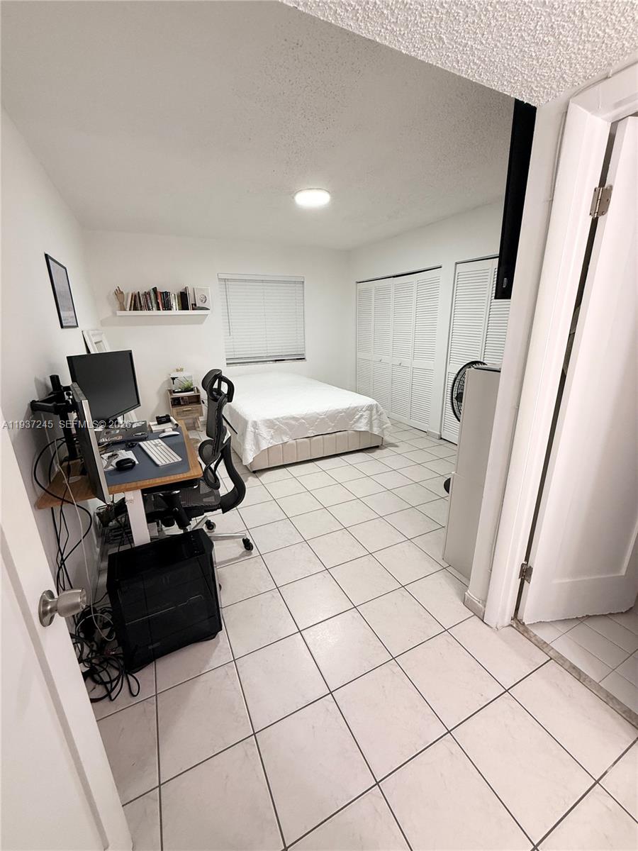 3262 West 70th Street, Unit 101 Hialeah, FL 33018 - Photo 13 of 20 a bedroom with a bed and a refrigerator