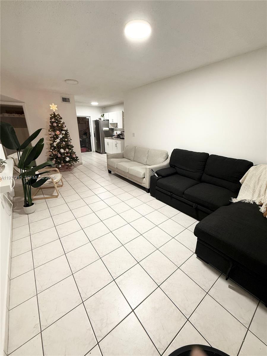 3262 West 70th Street, Unit 101 Hialeah, FL 33018 - Photo 2 of 20 a living room with couches and a flat screen tv