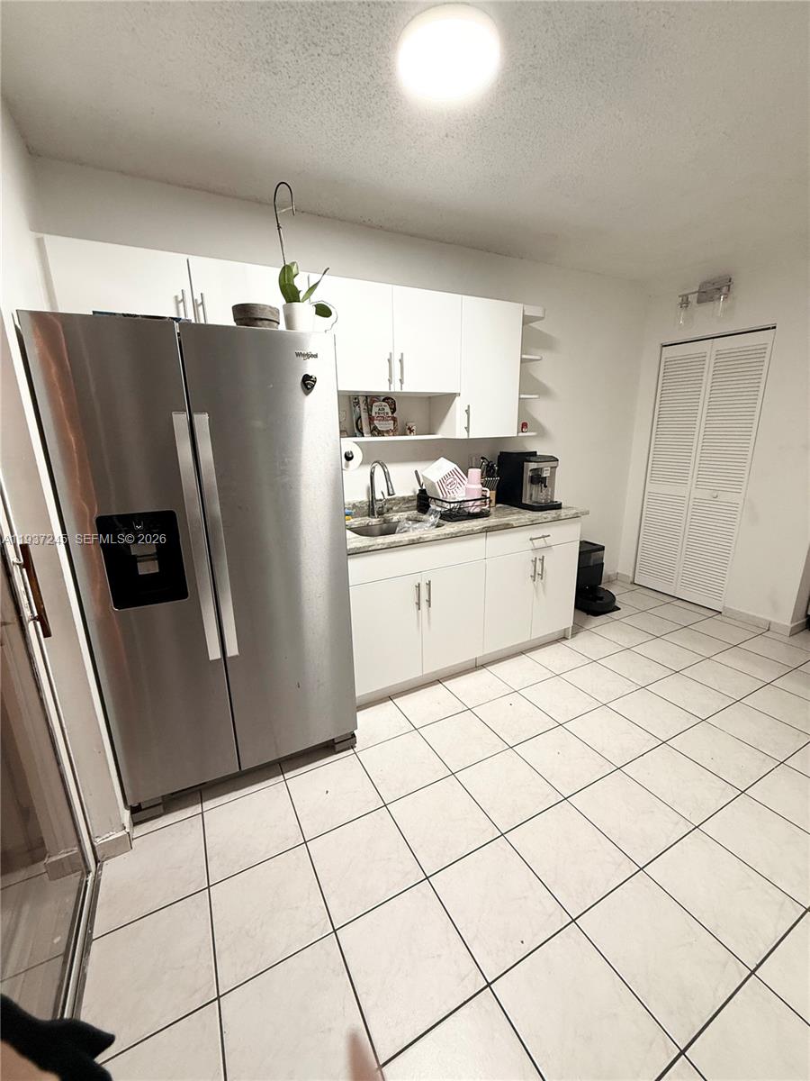 3262 West 70th Street, Unit 101 Hialeah, FL 33018 - Photo 7 of 20 a kitchen with granite countertop a refrigerator and a stove top oven