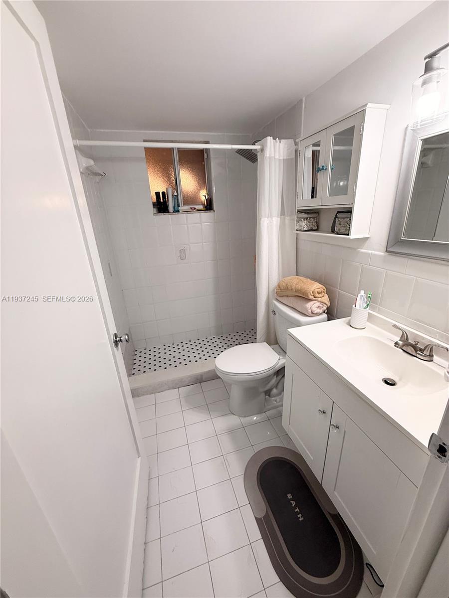 3262 West 70th Street, Unit 101 Hialeah, FL 33018 - Photo 10 of 20 a bathroom with a sink a toilet and mirror